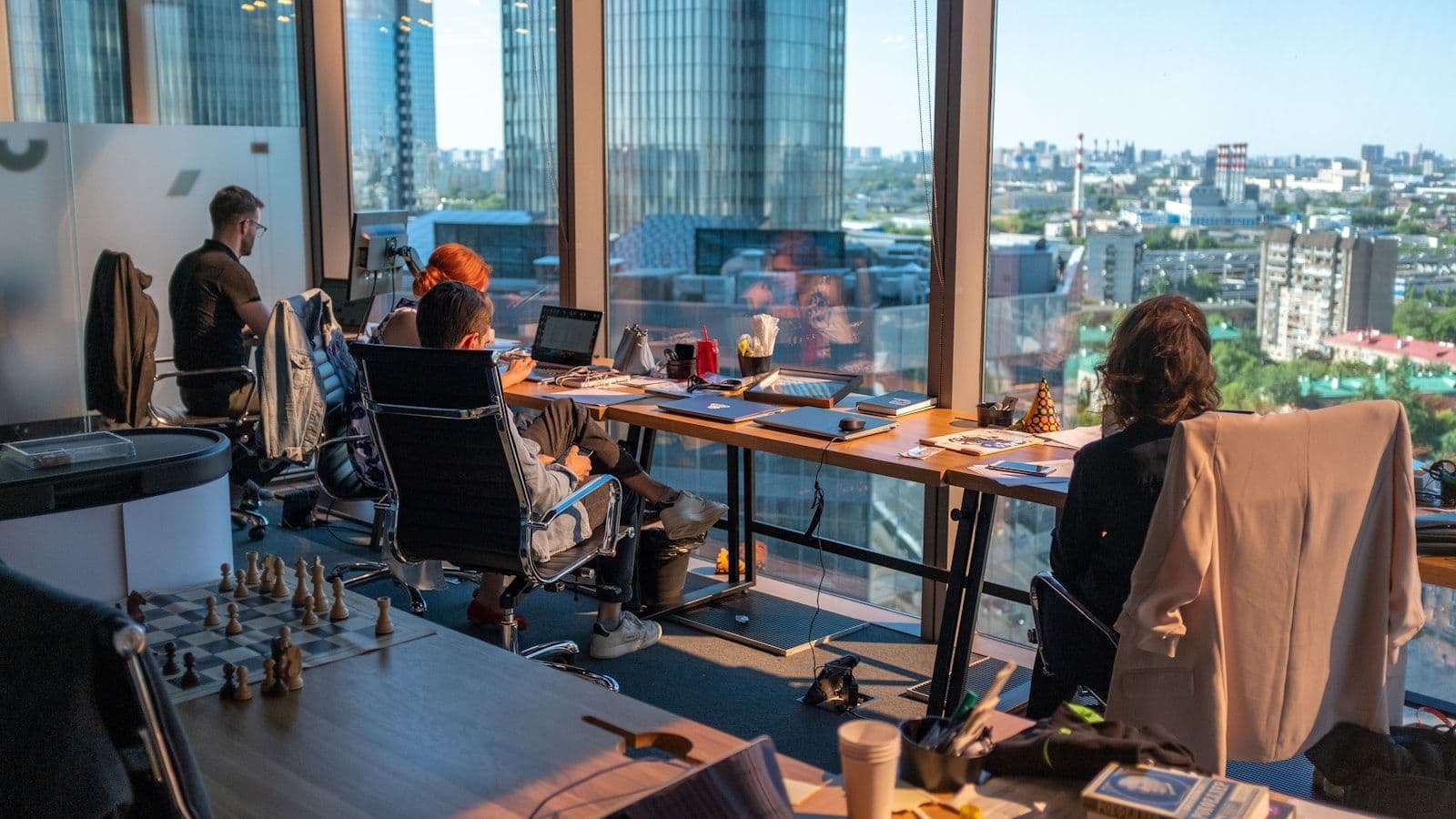 A marketing team working together in a high-rise office overlooking the city skyline